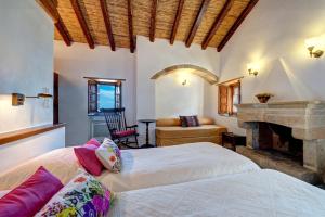 a bedroom with two beds and a fireplace at Malvasia Traditional Hotel in Monemvasia