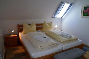 - une chambre avec 2 lits avec des oreillers et une fenêtre dans l'établissement Flurstrasse - OG rechts, à Wyk auf Föhr