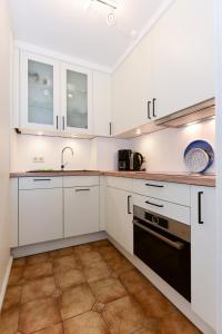 a kitchen with white cabinets and a sink at Haus Bornholm Whg 03 in Nieblum