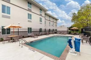 a swimming pool at a hotel with tables and chairs at Sleep Inn Lancaster Dallas South in Lancaster