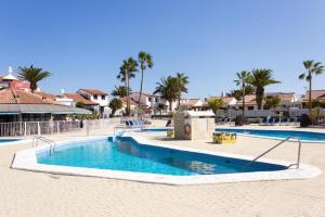 een zwembad in een resort met palmbomen bij Residencial Bitacora in San Miguel de Abona