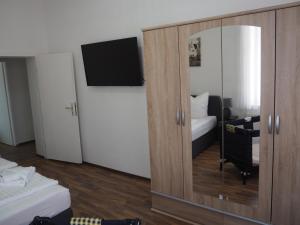 a room with a mirror and a bed and a tv at Askanier in Ballenstedt