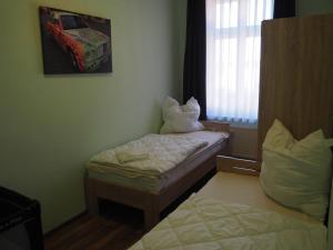 a small room with two beds and a window at Askanier in Ballenstedt