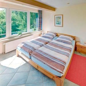 ein großes Bett in einem Zimmer mit Fenstern in der Unterkunft Ferienhaus Dittrich in Eckernförde
