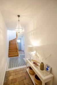 a hallway with a table with a lamp and stairs at Apartment No2 in Stralsund