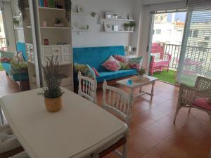 a living room with a couch and a table and chairs at Atico estudio en 1°linea Almuñecar in Almuñécar