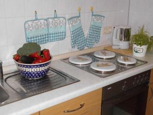 a kitchen with a stove with plates and a bowl of vegetables at Ferienwohnung "Im Pfarrhaus Marlow" in Marlow