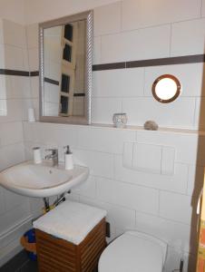 a bathroom with a sink and a toilet and a mirror at Ferienwohnung "Im Pfarrhaus Marlow" in Marlow