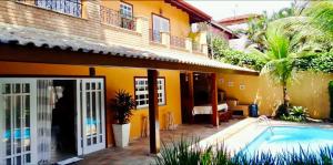 a house with a swimming pool next to a building at Casa com lazer a 2 minutos da Praia de Juquehy in São Sebastião