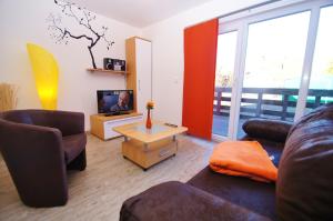 ein Wohnzimmer mit 2 Sofas und einem TV in der Unterkunft Bungalow Timm in Kellenhusen