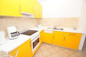 eine Küche mit gelben Schränken und einem Waschbecken in der Unterkunft Bungalow Timm in Kellenhusen