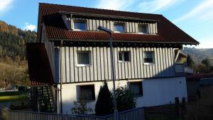 uma casa branca com um telhado vermelho em Pension Goldmann - Ferienwohnung 3 em Schönau im Schwarzwald