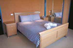 a bedroom with a large bed with blue and white sheets at The Penthouse in Port Fairy