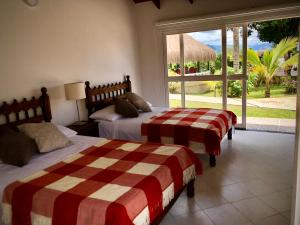 a bedroom with two beds and a large window at El Bongo de Chinauta in Fusagasuga