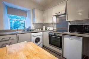 cocina con fregadero y lavavajillas en Cozy Newly Renovated Town Centre Apartment, en Aberfeldy