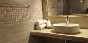 克勒尔Maple Leaf Hotel的带水槽、镜子和毛巾的浴室