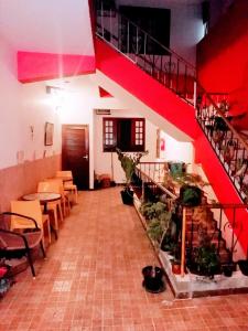 Albergue Rio Vermelho في سلفادور: مطعم فيه درج احمر وطاولات وكراسي