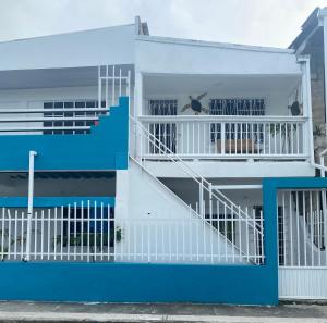 a white and blue house with a staircase at Fuentes House in San Andrés