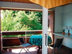 eine Terrasse mit einem Tisch, Stühlen und einem Fenster in der Unterkunft Ferienwohnung Riek in Büdelsdorf