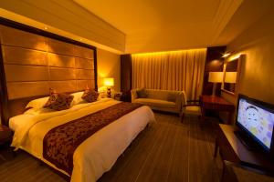 a hotel room with a bed and a flat screen tv at Seercuo International Hotel in Songpan