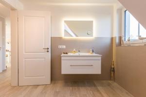 a bathroom with a white sink and a mirror at Whg 06 - De Fischer un sin Fru in Zingst