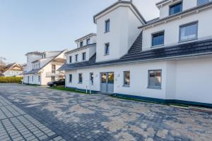 a cobblestone street in front of white buildings at Whg 06 - De Fischer un sin Fru in Zingst