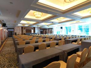 Habitación grande con hileras de sillas y mesas. en Seercuo International Hotel, en Songpan
