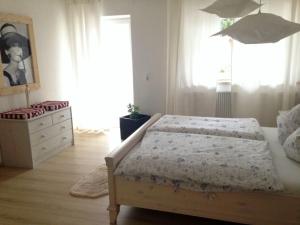 een slaapkamer met een bed, een dressoir en een raam bij Ferienwohnung SineFinibus in Bad Grönenbach