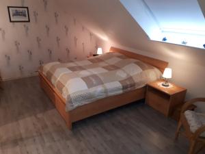 um quarto com uma cama, uma cadeira e uma janela em Ferienwohnung-Lilienweg em Hilter