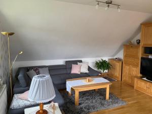 uma sala de estar com um sofá e uma mesa de centro em Ferienwohnung-Lilienweg em Hilter