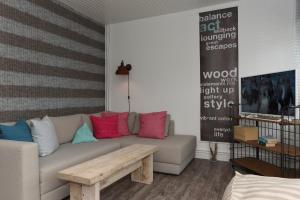 ein Wohnzimmer mit einem Sofa und bunten Kissen in der Unterkunft Surfbude 01 in Utersum