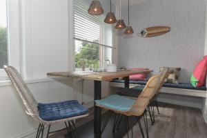 eine Küche mit einem Tisch und Stühlen sowie einem Fenster in der Unterkunft Surfbude 01 in Utersum