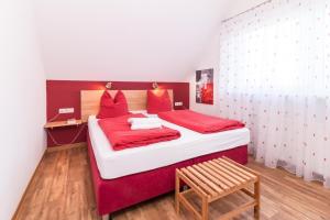 グレーミッツにあるW5 - Gästehaus Christian-Westphal-Str 60 - FERIENDOMIZIL HOLLICHのベッドルーム(赤と白のベッド1台、木製ベンチ付)