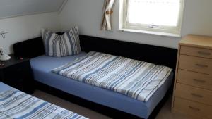 een kleine slaapkamer met een bed en een raam bij Fewo im "Schwedenhaus" in Prerow
