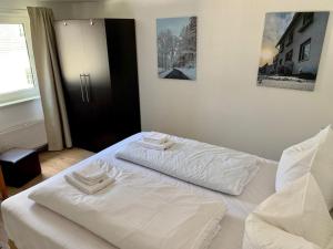 een slaapkamer met 2 bedden en witte lakens bij Ferienwohnung Winterberg Lodge in Winterberg