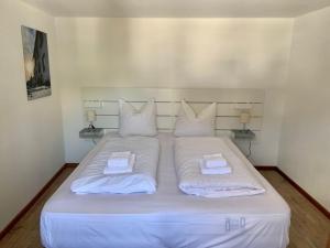 een groot wit bed met 2 kussens erop bij Ferienwohnung Winterberg Lodge in Winterberg
