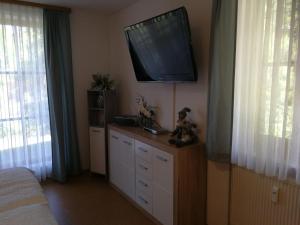 a bedroom with a flat screen tv on the wall at Blick zum Lallinger Winkel in Langfurth 
