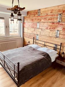 ein Schlafzimmer mit einer Holzwand und einem Bett in der Unterkunft COAST HOUSE River Docks in Bremerhaven