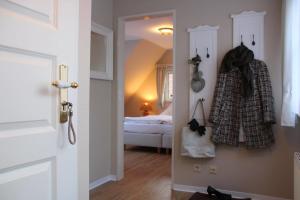 uma sala com um quarto com uma cama e uma porta em Dörphuus Wohnung Dorfblick em Spiekeroog