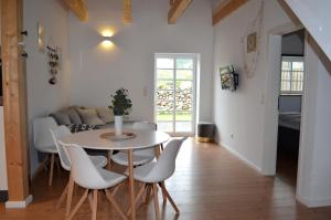 a dining room and living room with a table and chairs at Maritime Ferienwohnung auf Gut Bennewohld KP in Heide