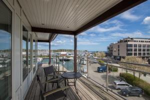 a balcony with chairs and a table and a view of a harbor at ancora Marina Haus 2 Penthouse in Neustadt in Holstein
