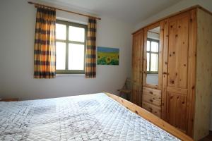 a bedroom with a bed and a wooden cabinet at Strandlöper in Wustrow