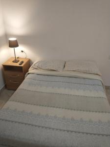 a bed in a bedroom with a nightstand and a bed sidx sidx sidx sidx at Habitación con baño privado en edificio 1er piso in San Salvador de Jujuy