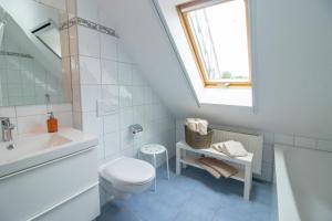 a white bathroom with a toilet and a sink at Huxfeld-Hof - Wörpe in Grasberg