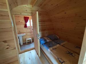 a small room with a bed and a sink in a log cabin at Glamping POD in Wittenborn