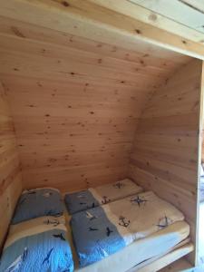 two beds in a wooden attic room at Glamping POD in Wittenborn
