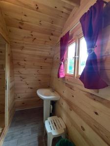 a bathroom in a log cabin with a sink and a window at Glamping POD in Wittenborn