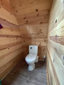 a bathroom with a toilet in a wooden cabin at Glamping POD in Wittenborn