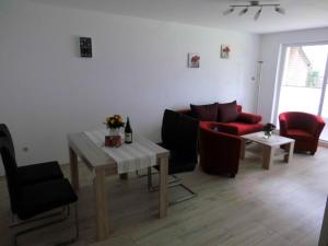 ハイリゲンハーフェンにあるMaggie's Goode Stuuvのリビングルーム(テーブル、赤い椅子付)