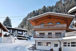 a house with a balcony on top of it in the snow at Maries Ferienhaus MAY-100 in Mayrhofen